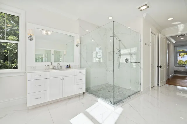 a bathroom with a granite countertop sink mirror and shower