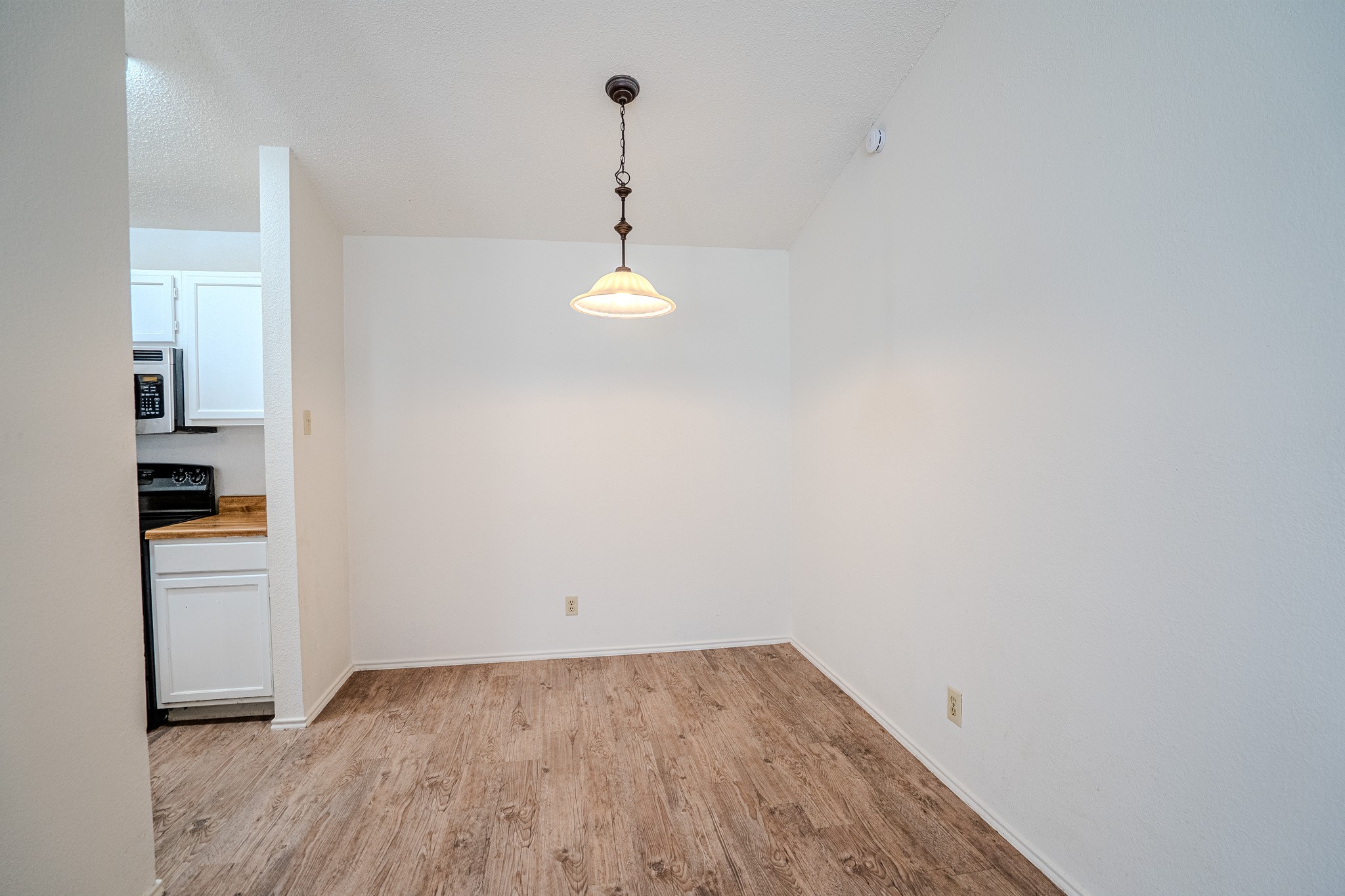 517 Cutty Trail, Unit B Lakeway, TX 78734 - Photo 5 of 16 A quaint dining area with wood-look flooring connects seamlessly to a compact kitchen.