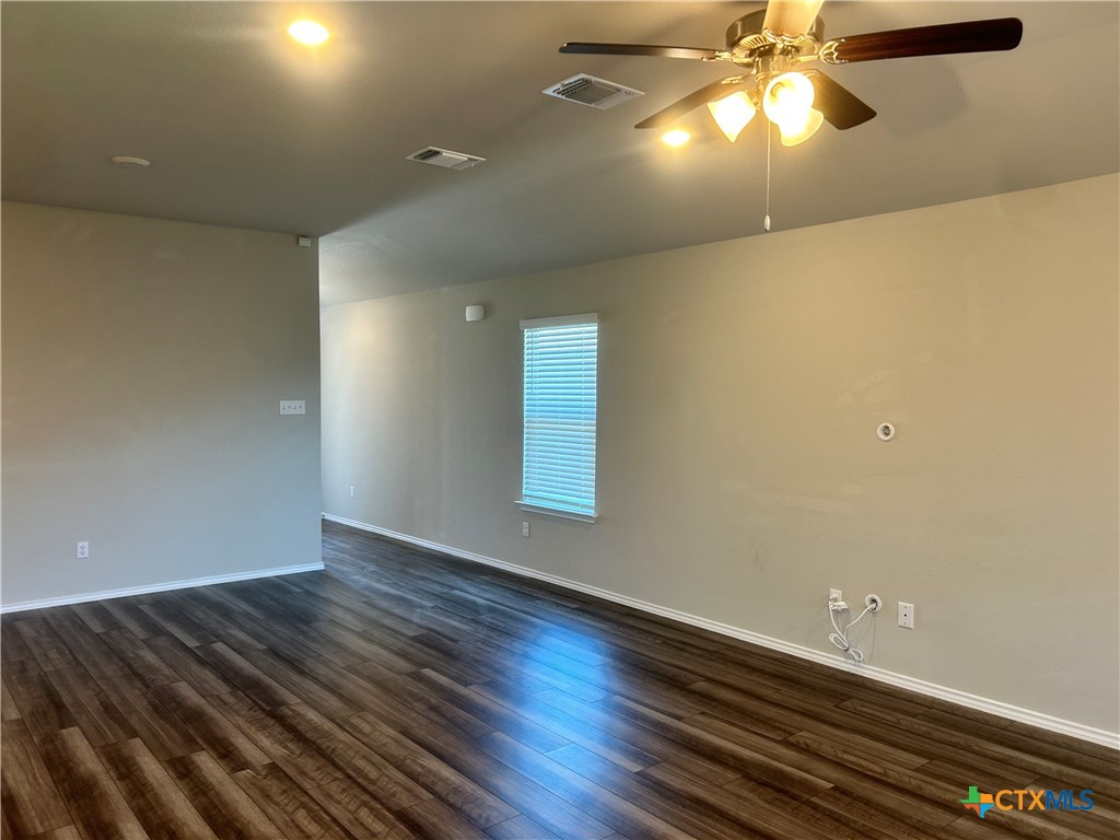 8419 Brahma Plns Road Temple, TX 76502 - Photo 5 of 17 an empty room with wooden floor fan and window