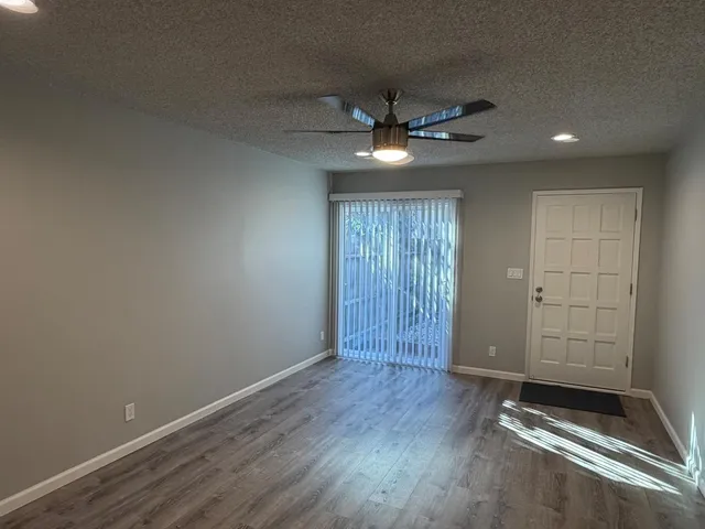 an empty room with wooden floor closet and ceiling fan