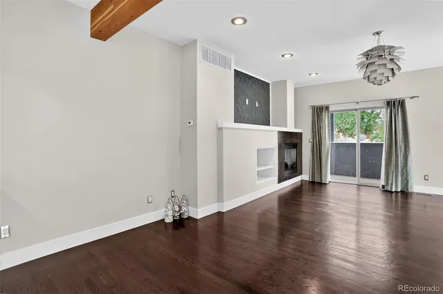 an empty room with wooden floor a ceiling fan and a window
