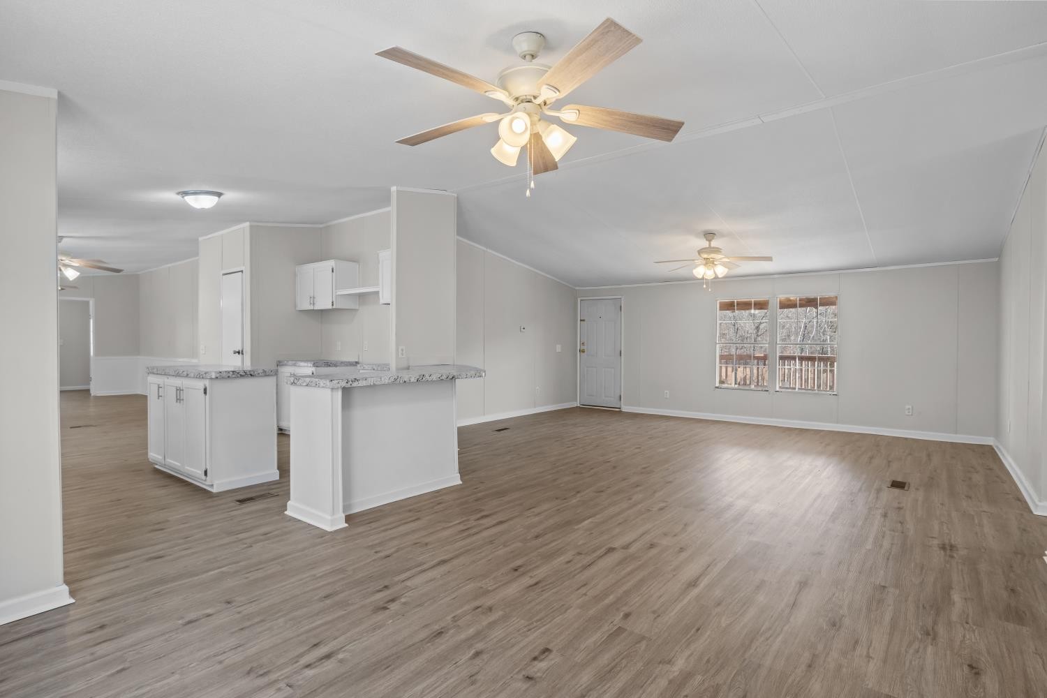 624 Nickletown Road Sugar Tree, TN 38380 - Photo 12 of 45 a view of an empty room with a kitchen and wooden floor