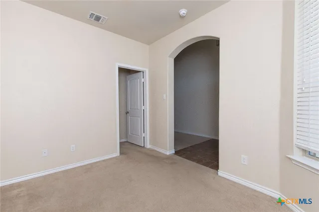 an empty room with windows and closet