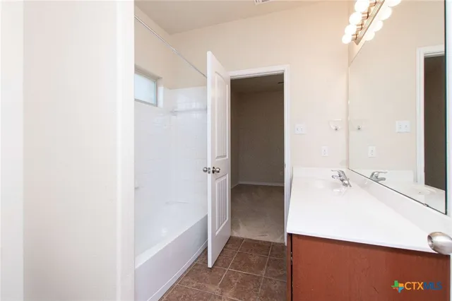 a bathroom with a tub shower and sink