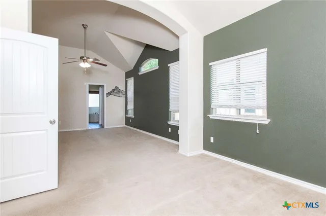 a view of a room with a ceiling fan and a window