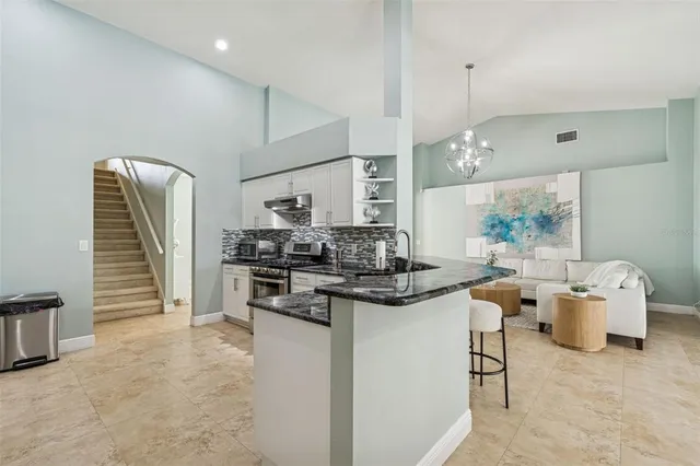 a bathroom with a granite countertop toilet a sink a mirror a shower and a window