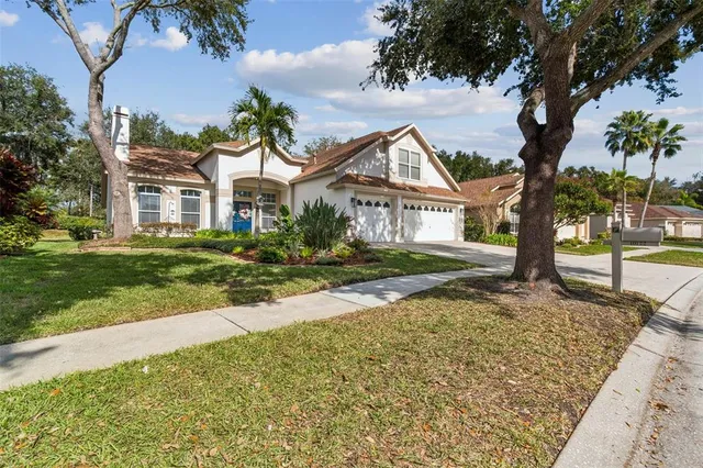 a view of a white house with a large windows and a yard with plants