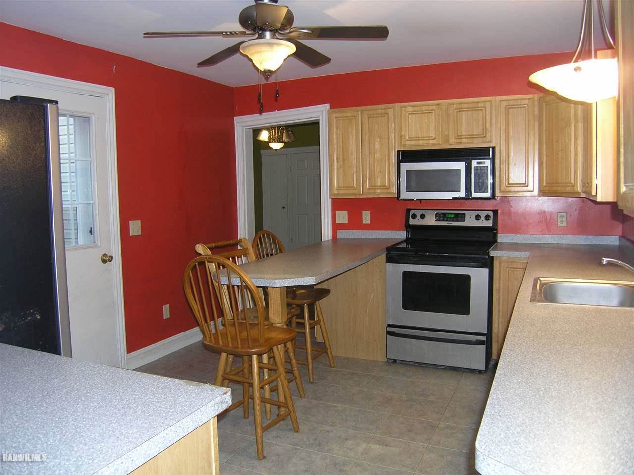 313 South Bench Street Galena, IL 61036 - Photo 15 of 19 a kitchen with stainless steel appliances kitchen island granite countertop a table chairs and a refrigerator
