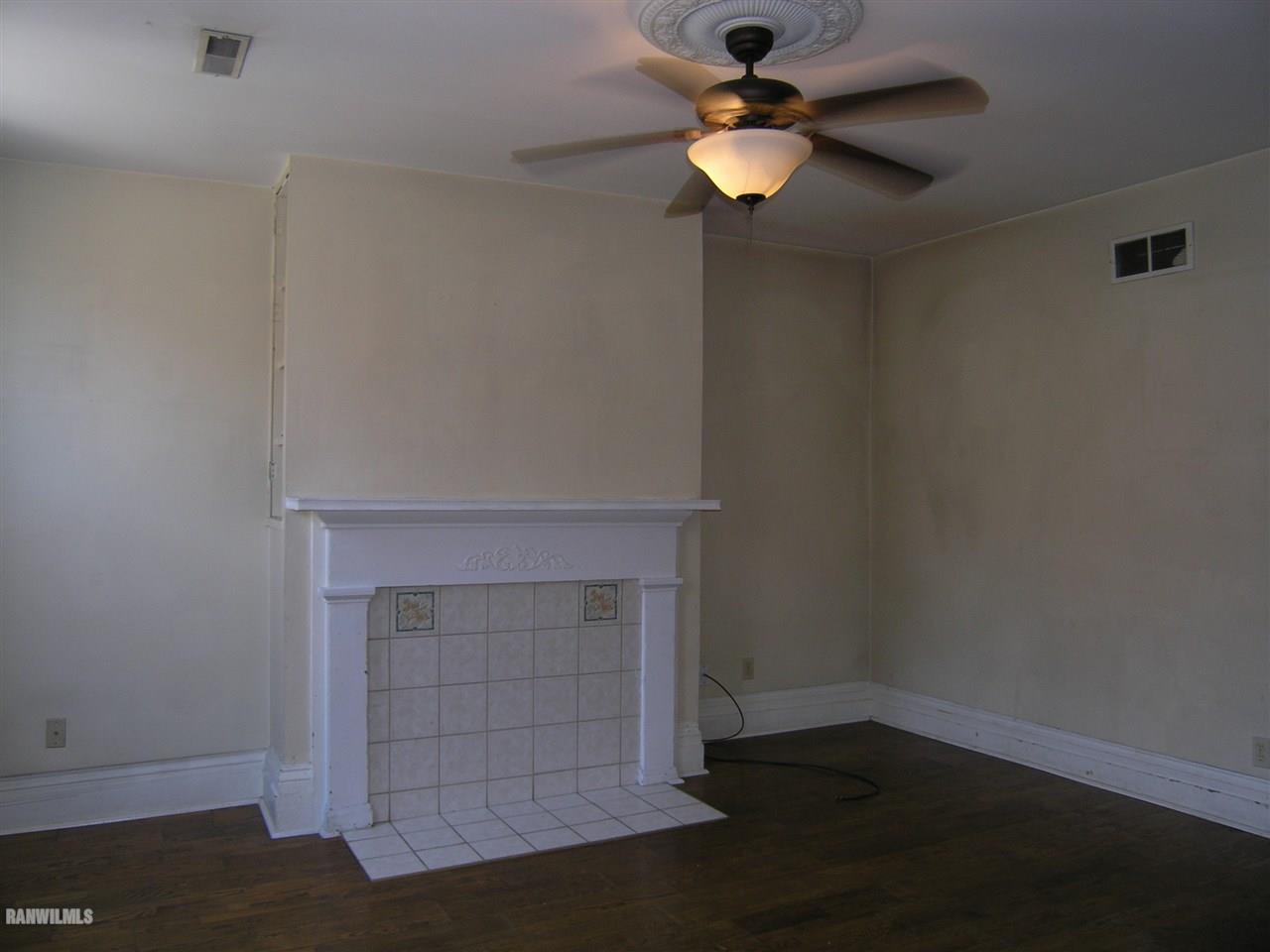 313 South Bench Street Galena, IL 61036 - Photo 6 of 19 an empty room with a fireplace and fan