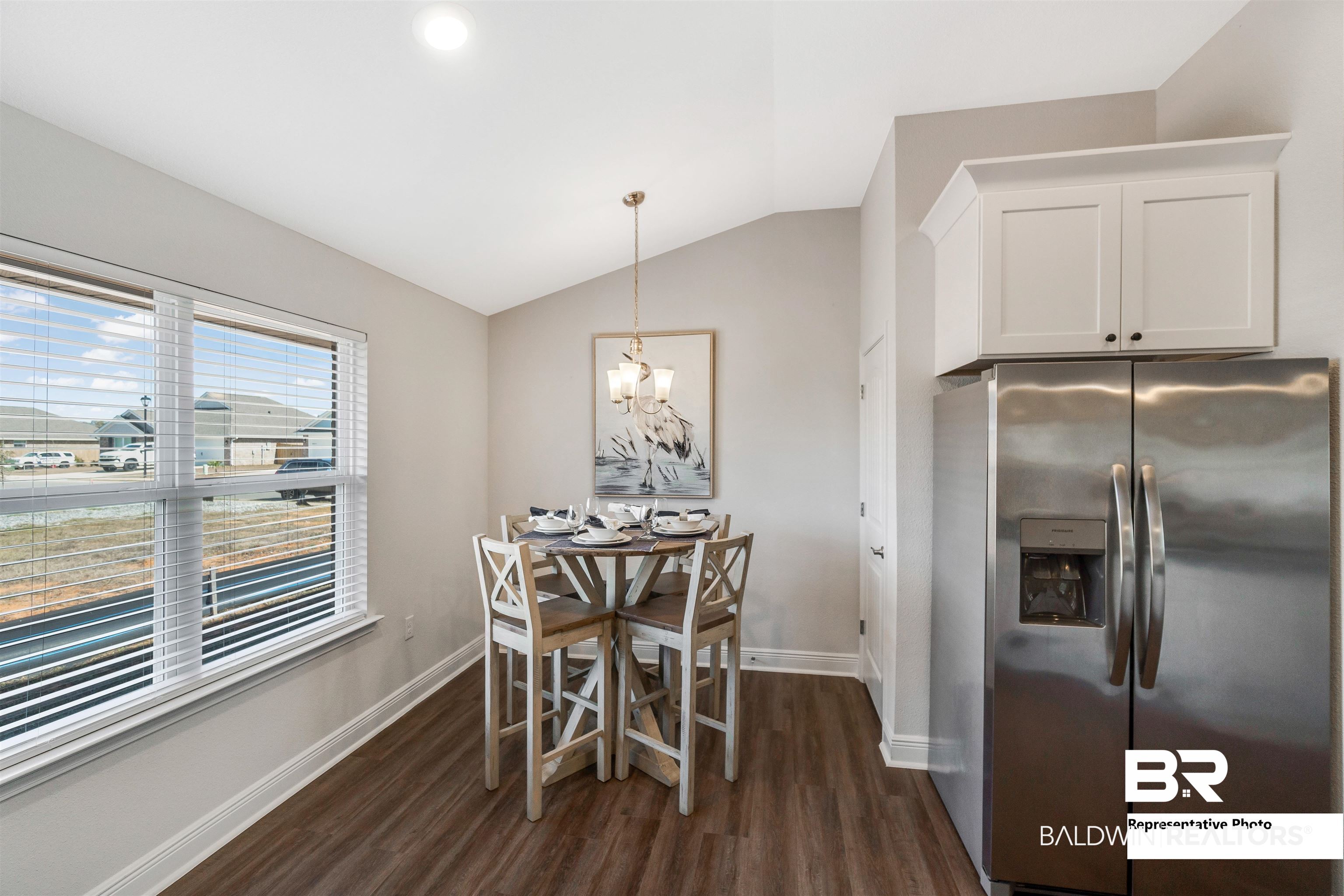 643 Mayflower Drive Foley, AL 36535 - Photo 10 of 34 Dining space featuring a chandelier, dark wood finished floors, vaulted ceiling, and baseboards