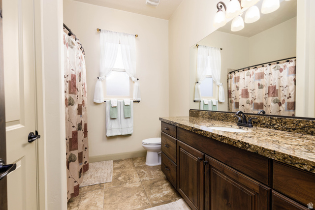 2005 West 450 S Circle St. George, UT 84770 - Photo 7 of 57 Bathroom featuring a dark wood-finish vanity with a stone countertop, a single basin sink, and an overhead vanity light fixture