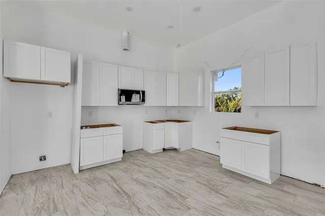 a kitchen with stainless steel appliances a refrigerator sink and white cabinets