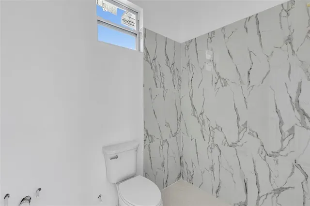 a bathroom with a toilet and a shower curtain