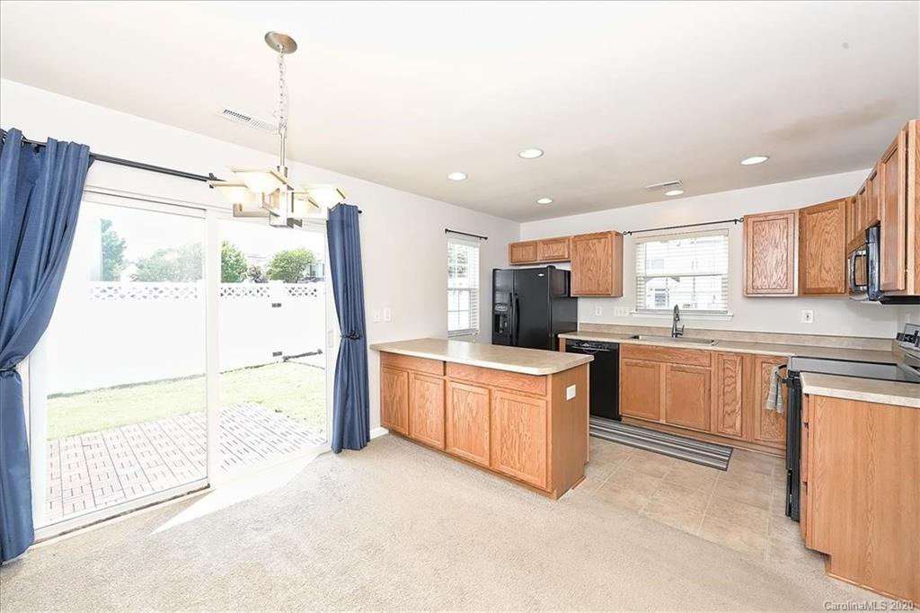 231 Primrose Walk Fort Mill, SC 29715 - Photo 14 of 34 a kitchen with stainless steel appliances granite countertop a refrigerator a sink dishwasher a stove and white cabinets with wooden floor