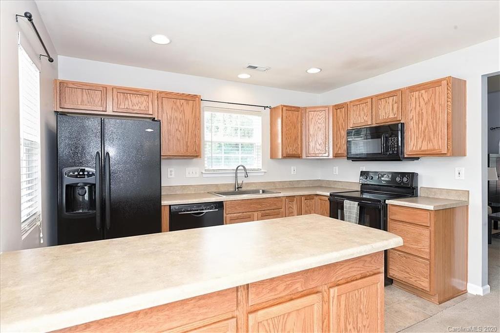 231 Primrose Walk Fort Mill, SC 29715 - Photo 16 of 34 a kitchen with granite countertop a refrigerator stove top oven and sink