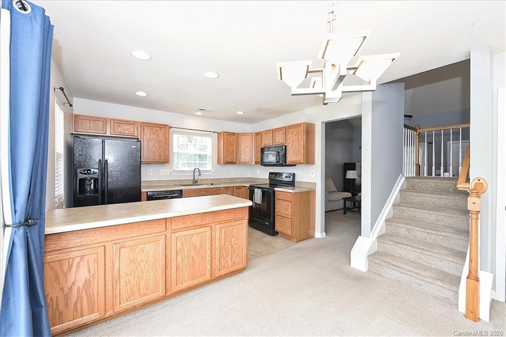 231 Primrose Walk Fort Mill, SC 29715 - Photo 18 of 34 a large kitchen with stainless steel appliances kitchen island granite countertop a refrigerator and microwave