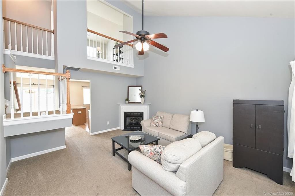 231 Primrose Walk Fort Mill, SC 29715 - Photo 4 of 34 a living room with furniture a bed and a chandelier