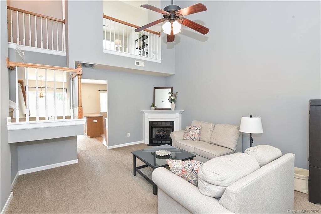 231 Primrose Walk Fort Mill, SC 29715 - Photo 5 of 34 a living room with furniture a fireplace and a large window