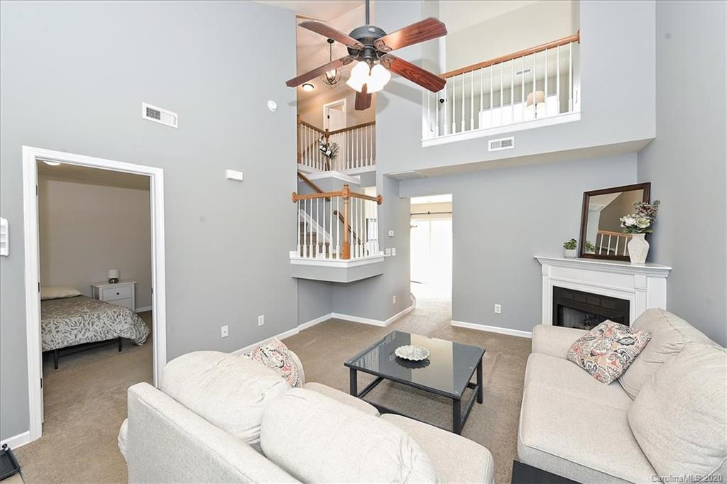 231 Primrose Walk Fort Mill, SC 29715 - Photo 6 of 34 a living room with furniture a fireplace and a chandelier