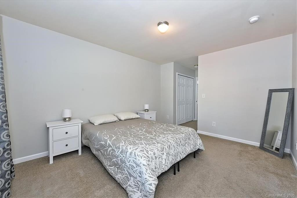 231 Primrose Walk Fort Mill, SC 29715 - Photo 8 of 34 a bedroom with a bed and a flat tv screen on the dresser