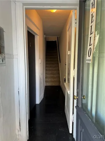 a view of a hallway with a door and stairs