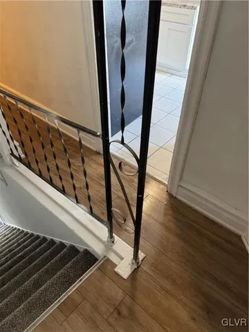 a view of a hallway with wooden floor and staircase