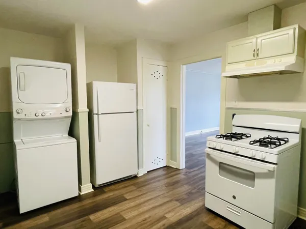 a white refrigerator freezer and a stove sitting inside of a kitchen