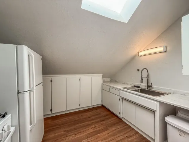 a kitchen with a sink a refrigerator and cabinets