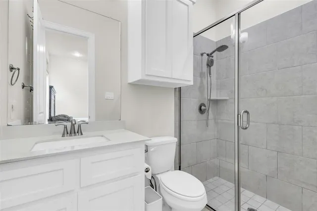 a bathroom with a sink toilet vanity and shower