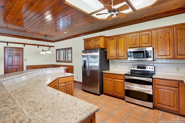 a kitchen with stainless steel appliances granite countertop a refrigerator stove microwave and sink