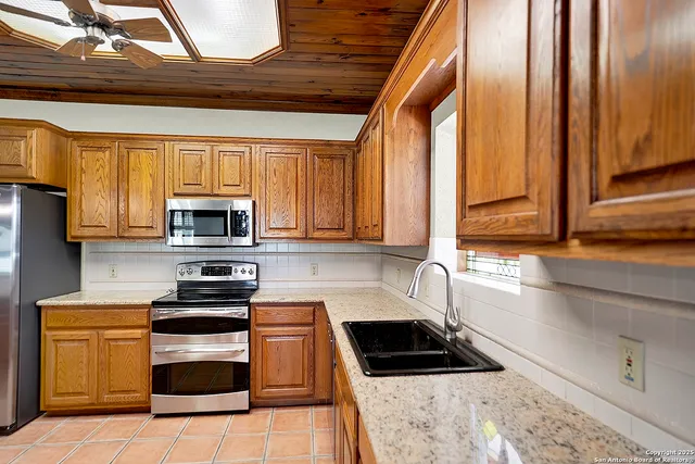 a kitchen with stainless steel appliances granite countertop a stove a sink and a microwave