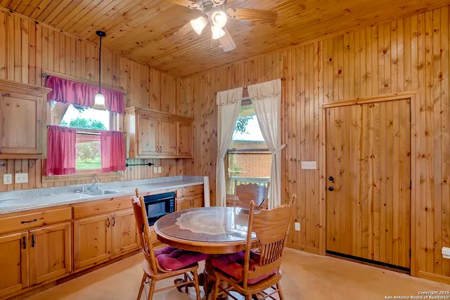 a kitchen with stainless steel appliances granite countertop a stove a sink a dining table and chairs