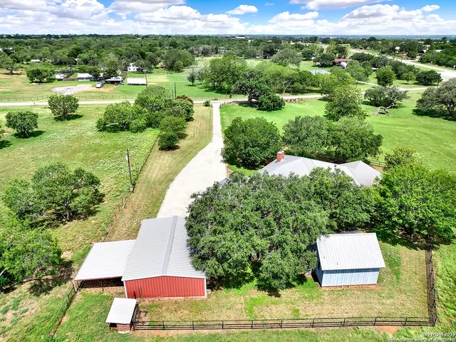 an aerial view of a house with a yard and lake view