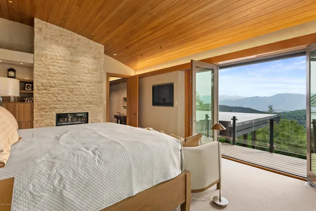 a bedroom with a bed and a large window with balcony view
