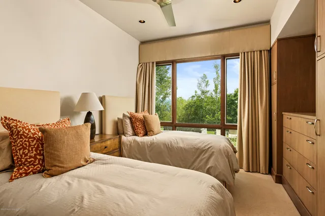 a bedroom with two beds and a large window