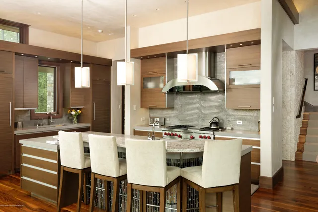 a kitchen with a table chairs stove and wooden floor