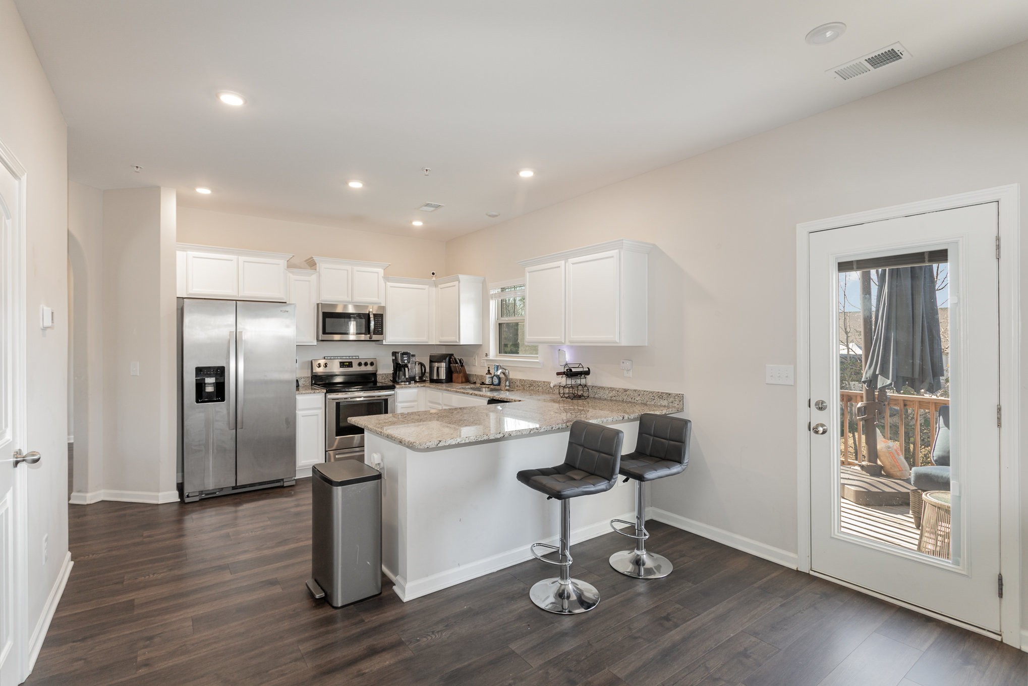 809 Callie Lane Pleasant View, TN 37146 - Photo 11 of 30 a kitchen with stainless steel appliances kitchen island granite countertop a refrigerator a stove a sink and a dining table with wooden floor