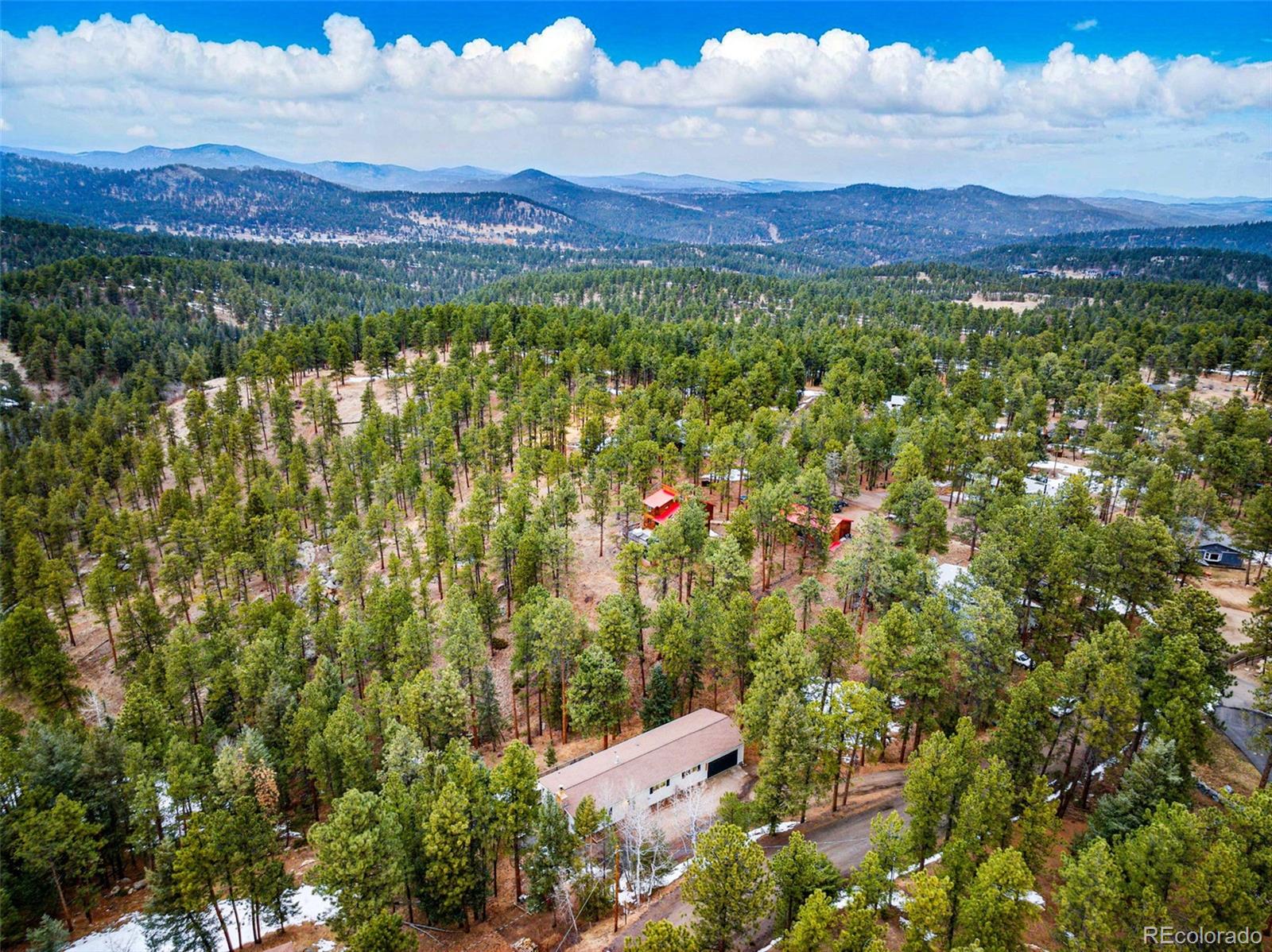 28254 Tresine Drive Evergreen, CO 80439 - Photo 3 of 44 a view of a lush green field with mountains in the background