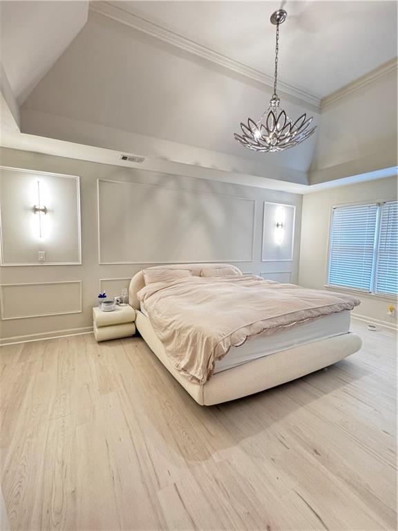 320 Morning Mist Walk Suwanee, GA 30024 - Photo 12 of 19 a bedroom with a large bed and a chandelier