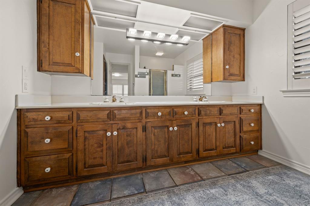 10902 Clear Creek Road West Sanger, TX 76266 - Photo 12 of 40 Full bathroom featuring a stall shower, double vanity, and dark stone finish flooring