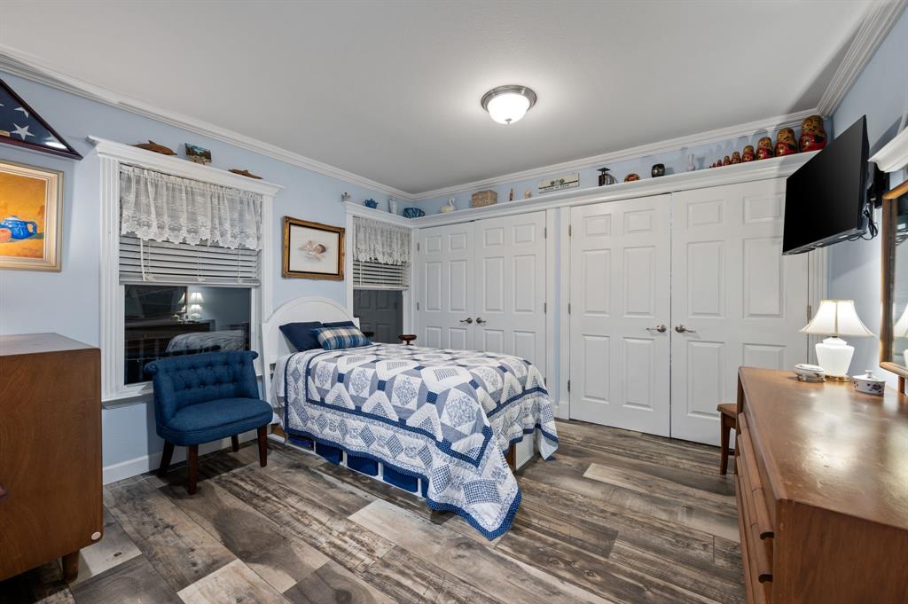 10902 Clear Creek Road West Sanger, TX 76266 - Photo 33 of 40 2nd House Bedroom with multiple closets, crown molding, and dark wood-style floors