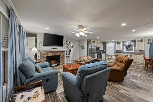 a kitchen with stainless steel appliances granite countertop a refrigerator a stove a sink a dining table and chairs