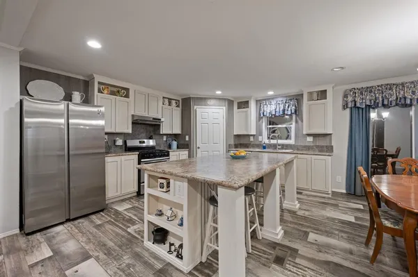 a kitchen with granite countertop a sink stove and cabinets