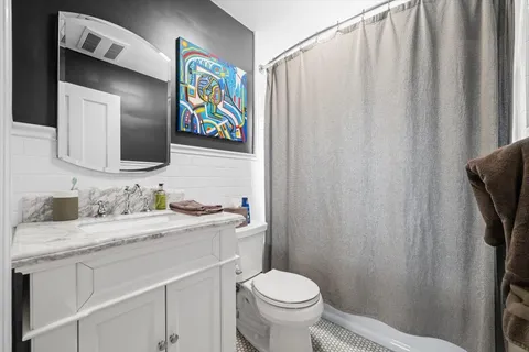 a bathroom with a granite countertop sink toilet and mirror