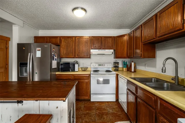 a kitchen with a sink a refrigerator and cabinets