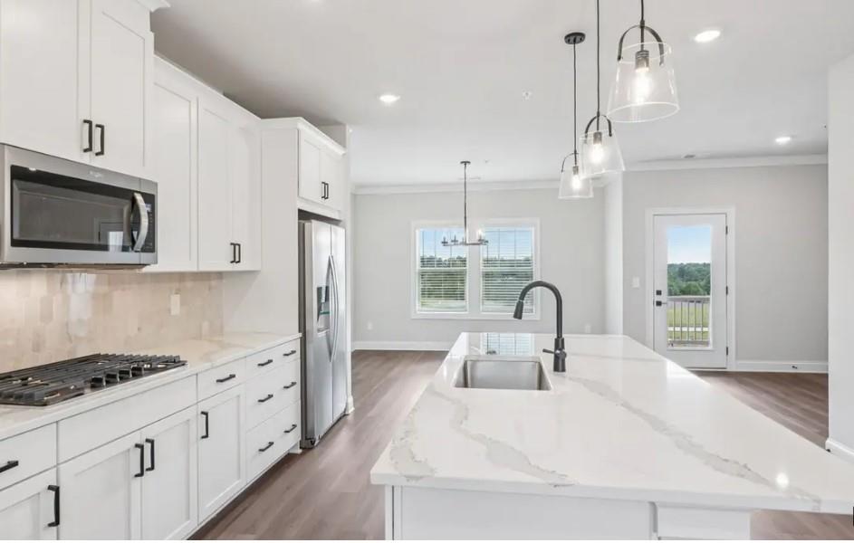 6060 Molo Lane Cumming, GA 30041 - Photo 4 of 14 a kitchen with granite countertop a stove a sink and a refrigerator