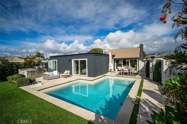 a view of a house with backyard sitting area and swimming pool