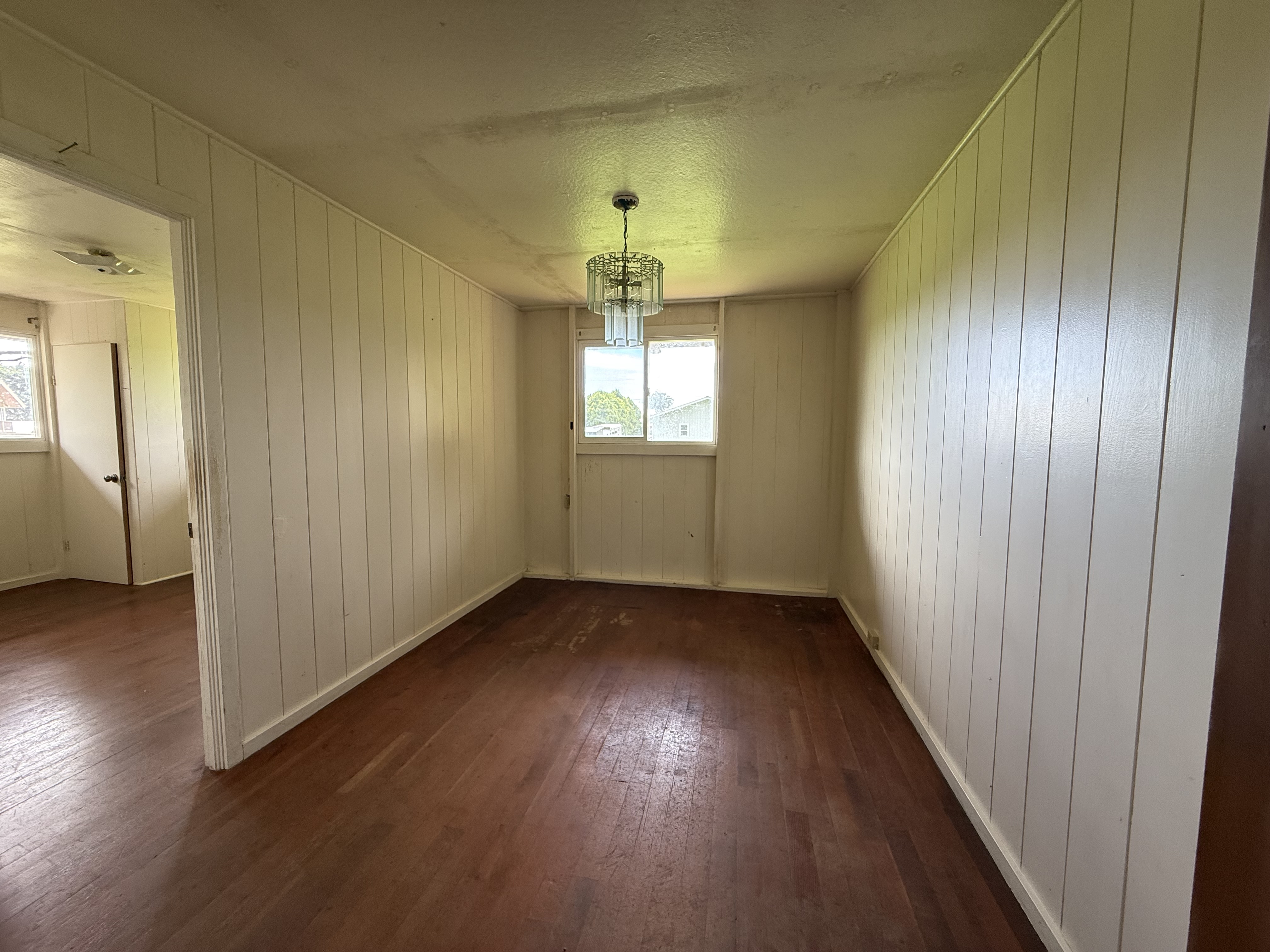 64-5231 White Road Kamuela, HI 96743 - Photo 5 of 15 an empty room with wooden floor chandelier and windows