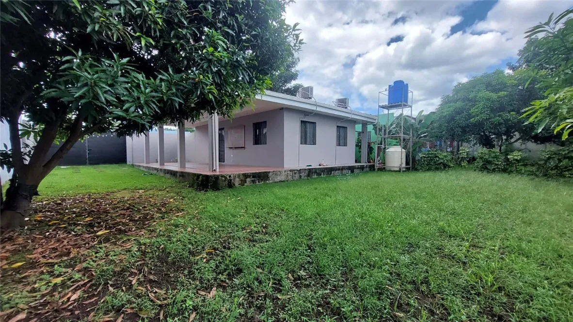 13 Masaya Highway Schenectady, OS 12345 - Photo 4 of 12 a white house with a small yard and large trees