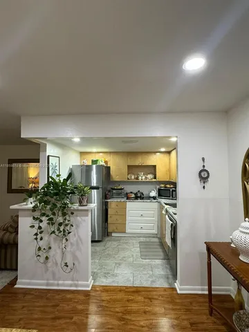 a kitchen with stainless steel appliances kitchen island granite countertop a stove refrigerator and cabinets